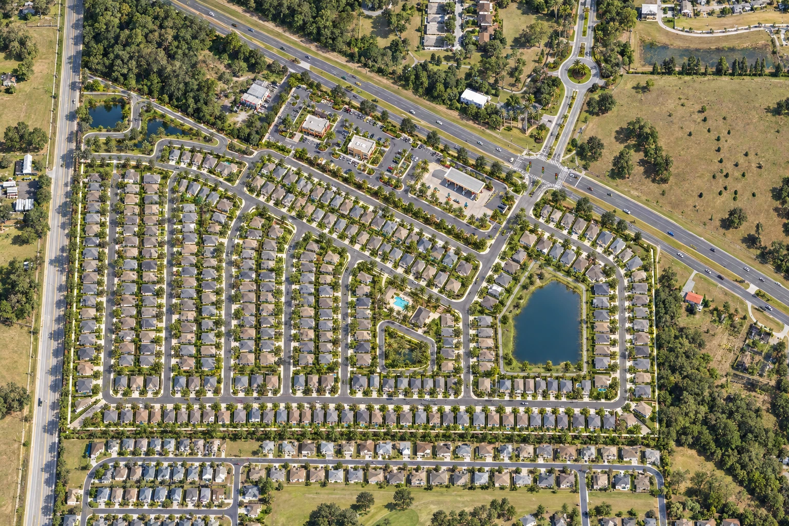 Concept rendering based on Stancil Pineywoods site-plan shape, with signal, gas station and food outparcels along the commercial frontage and homes behind